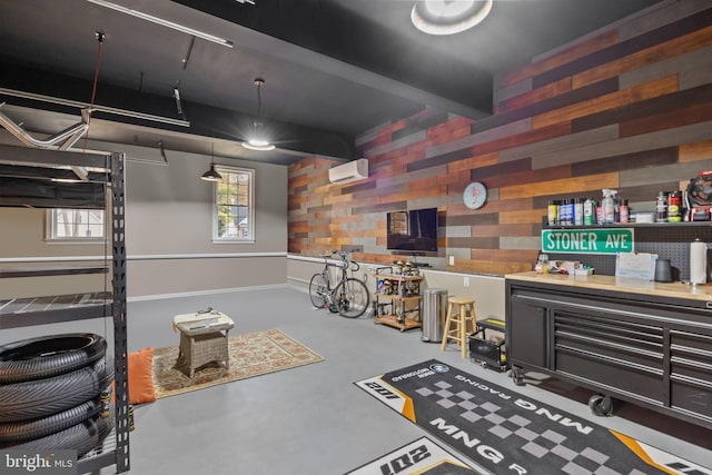 misc room featuring an AC wall unit, finished concrete flooring, wood walls, and beam ceiling