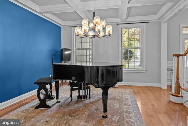 living area with ornamental molding, coffered ceiling, baseboards, and wood finished floors