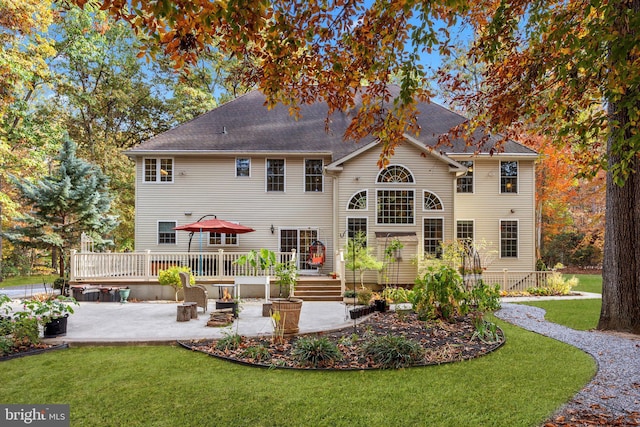 rear view of house with a patio area, a lawn, and a wooden deck