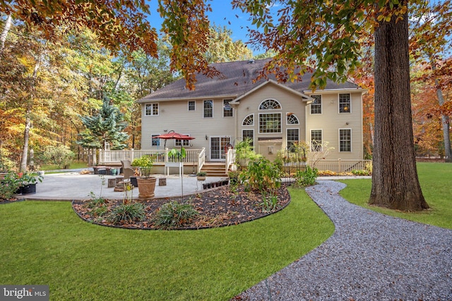 back of property featuring a deck, a patio, a yard, and fence