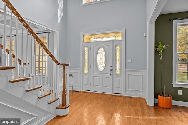 foyer entrance with a decorative wall, plenty of natural light, and wood-type flooring