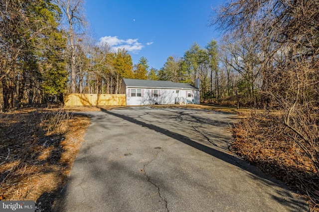 view of outbuilding with fence and driveway