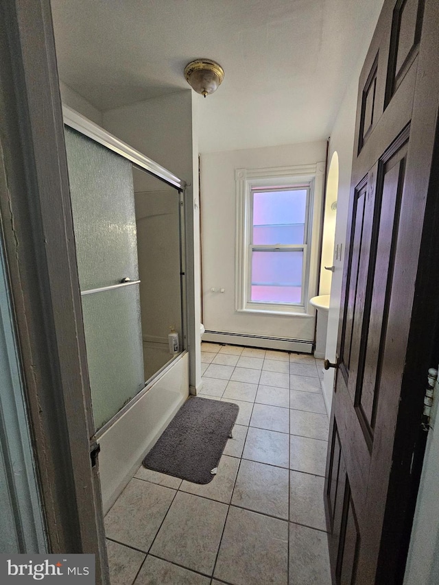 full bathroom with tile patterned flooring, combined bath / shower with glass door, toilet, and a baseboard radiator