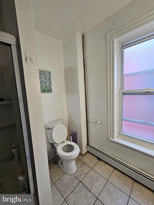 bathroom with tile patterned flooring, toilet, and a baseboard radiator