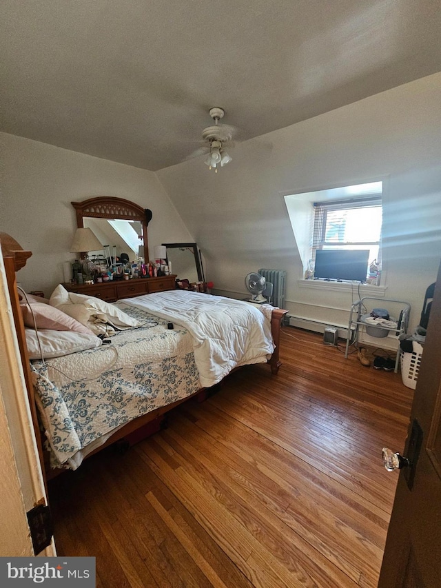 bedroom featuring wood-type flooring, lofted ceiling, ceiling fan, and radiator heating unit