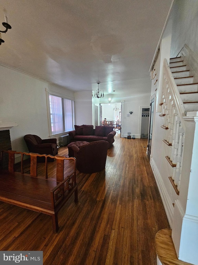 living area featuring dark wood-type flooring, radiator heating unit, stairs, an inviting chandelier, and a textured ceiling