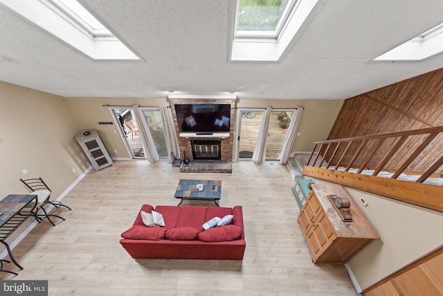 living area featuring stairway, wood finished floors, and a skylight