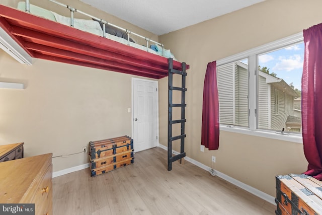 bedroom with baseboards and wood finished floors