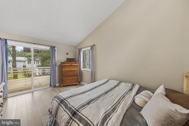 bedroom with baseboards, light wood finished floors, lofted ceiling, access to exterior, and a textured ceiling