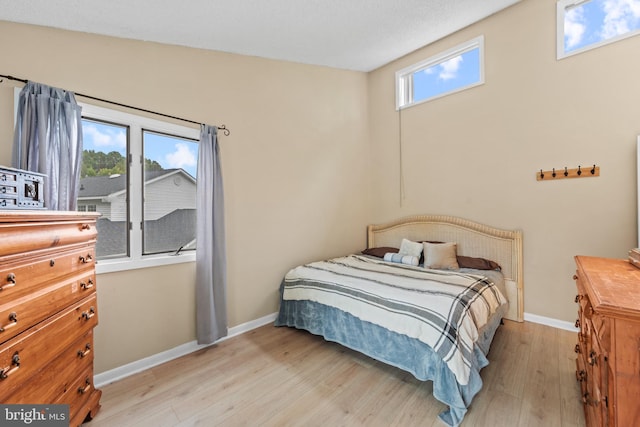 bedroom with baseboards and light wood finished floors