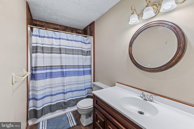 full bathroom with toilet, vanity, shower / bath combo, wood finished floors, and a textured ceiling