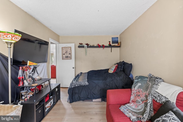 bedroom with wood finished floors and a textured ceiling