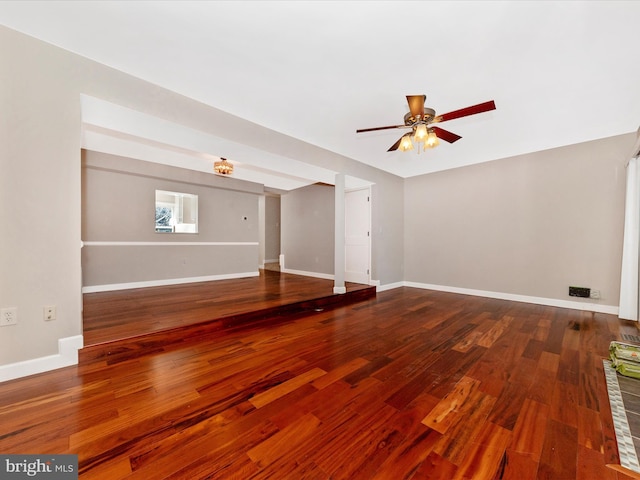 unfurnished living room featuring a ceiling fan, baseboards, and wood finished floors