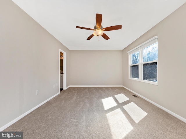 carpeted empty room featuring visible vents, baseboards, and ceiling fan