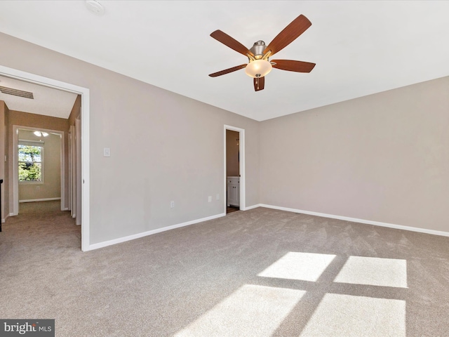 carpeted empty room featuring visible vents, ceiling fan, and baseboards