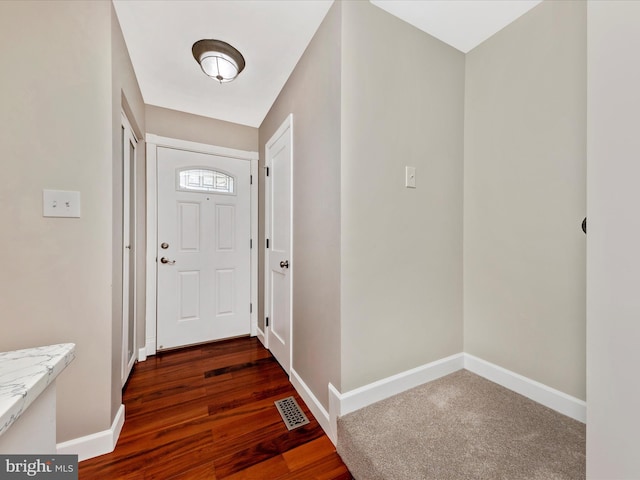 entryway featuring dark wood-type flooring, baseboards, and visible vents