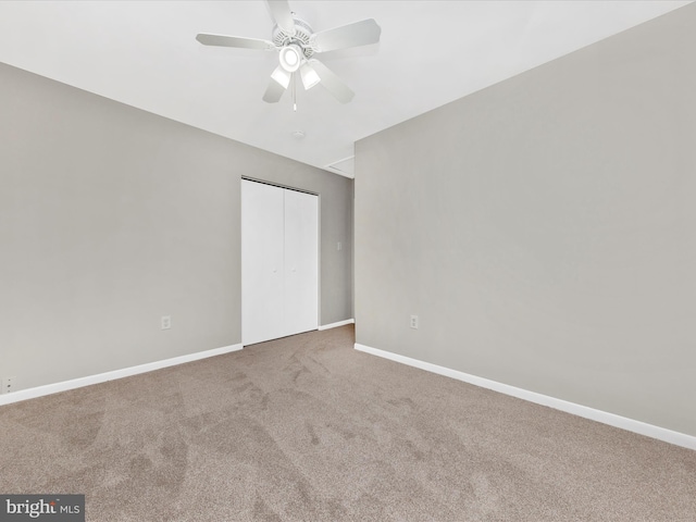 unfurnished bedroom featuring a closet, carpet flooring, a ceiling fan, and baseboards