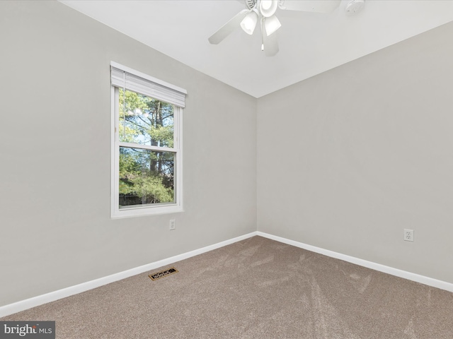 carpeted empty room featuring visible vents, baseboards, and a ceiling fan