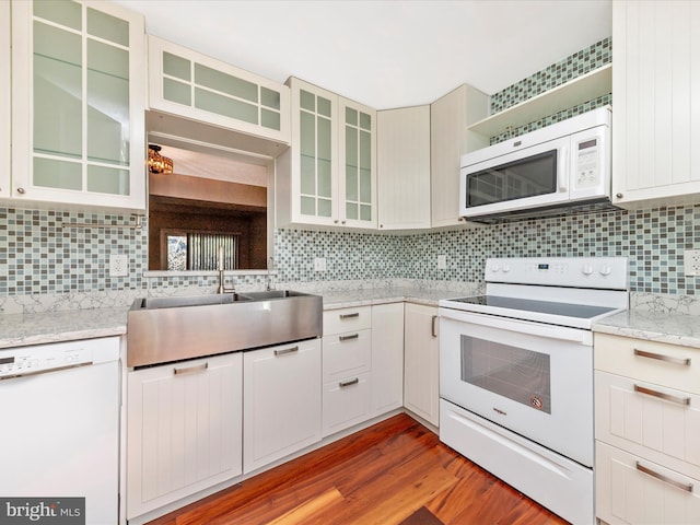 kitchen with open shelves, a sink, tasteful backsplash, wood finished floors, and white appliances