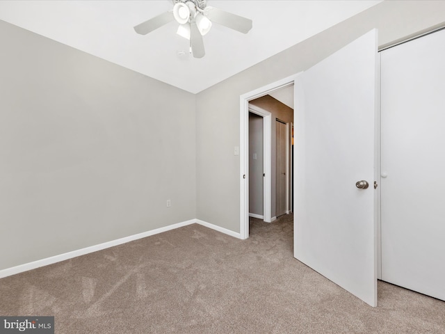 unfurnished bedroom featuring carpet, baseboards, a closet, and ceiling fan