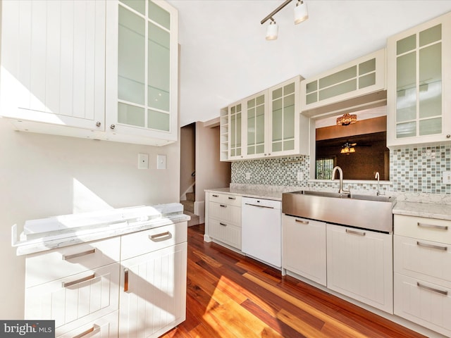 kitchen featuring decorative backsplash, dishwasher, wood finished floors, and a sink