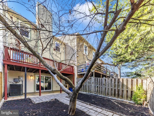 exterior space featuring fence, central air condition unit, a chimney, a deck, and a patio area