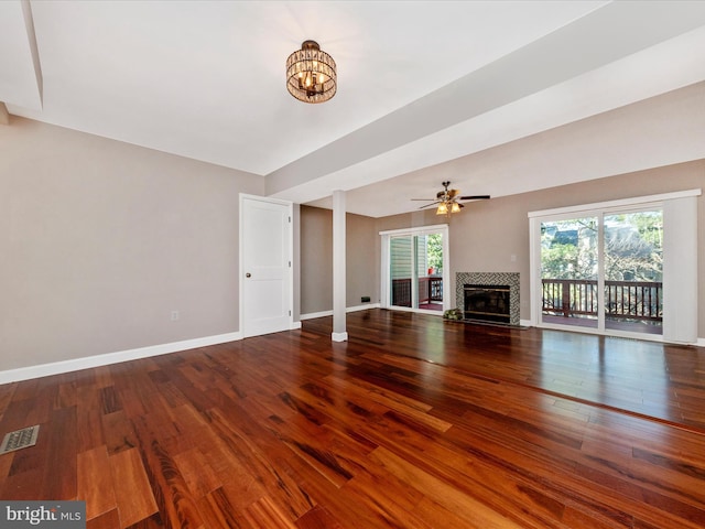 unfurnished living room featuring a wealth of natural light, visible vents, wood finished floors, and a fireplace