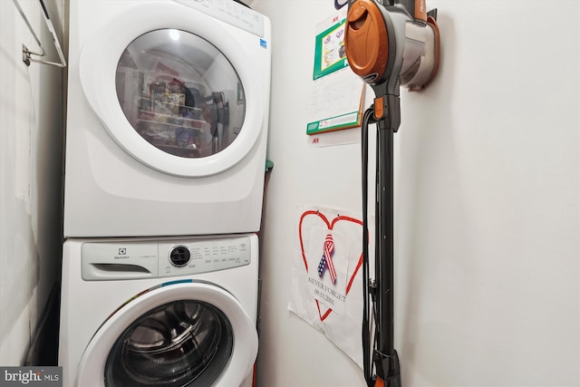 washroom with stacked washer / drying machine and laundry area