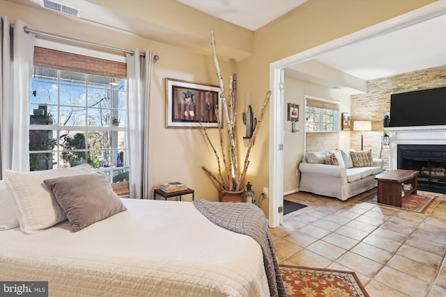 bedroom with light tile patterned floors, a fireplace, and visible vents