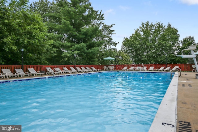 community pool with a patio and fence