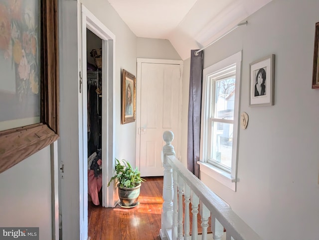 corridor featuring wood finished floors and an upstairs landing