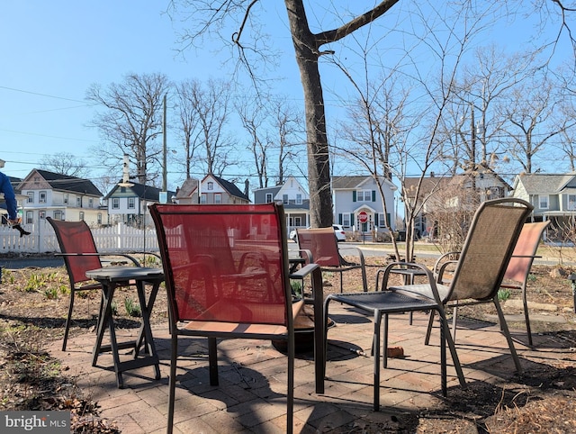 view of patio featuring fence and a residential view