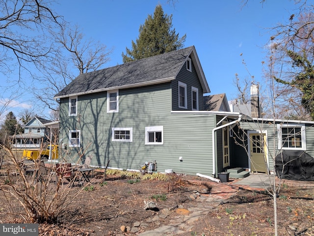 view of side of property featuring a chimney and entry steps