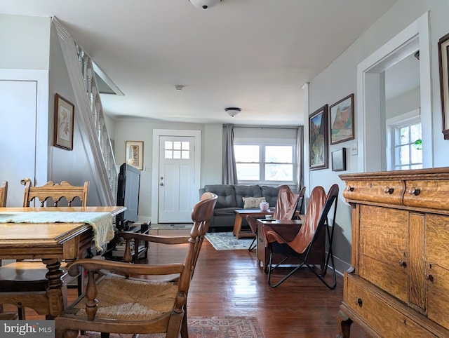 living room with a wealth of natural light, dark wood-type flooring, and baseboards