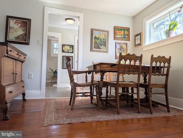 dining area featuring baseboards and hardwood / wood-style floors