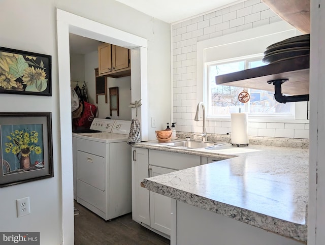 washroom featuring washer and clothes dryer, cabinet space, dark wood-type flooring, and a sink