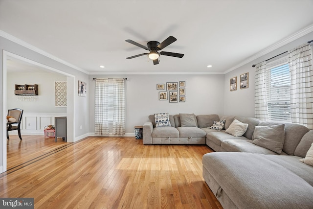 living area with a ceiling fan, baseboards, light wood-style flooring, recessed lighting, and ornamental molding