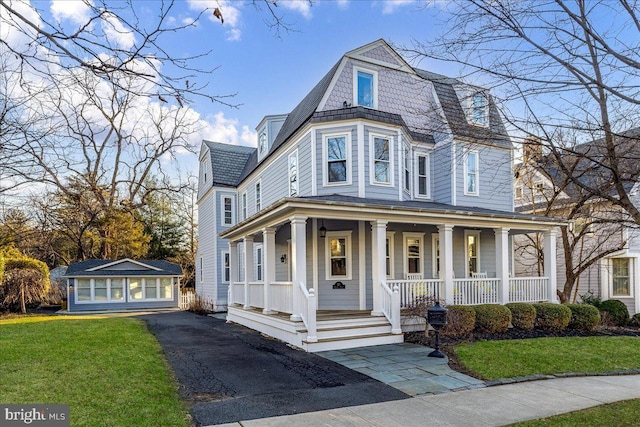 view of front of house featuring a front lawn, covered porch, and an outdoor structure