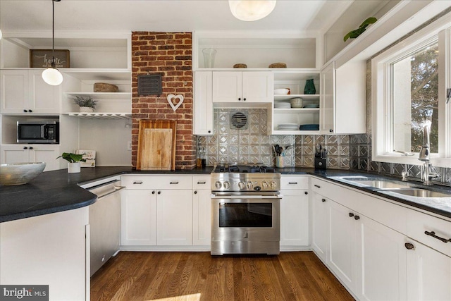 kitchen with open shelves, stainless steel appliances, dark countertops, and a sink