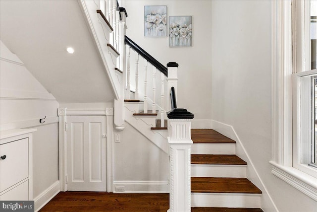 staircase featuring baseboards and wood finished floors