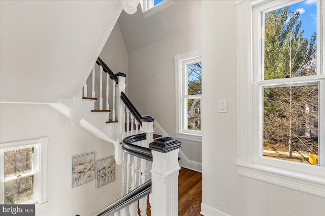 stairs featuring vaulted ceiling, baseboards, and wood finished floors