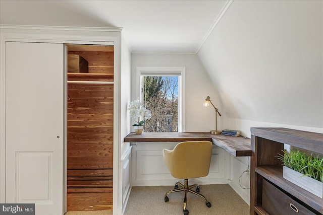 office featuring built in study area, lofted ceiling, ornamental molding, and light carpet