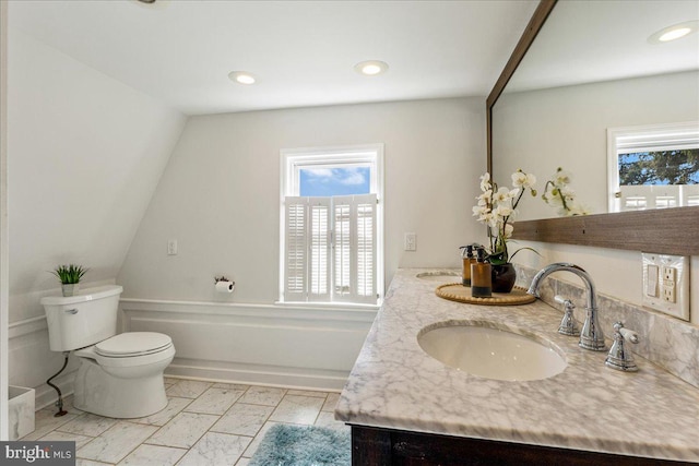 bathroom featuring toilet, double vanity, recessed lighting, marble finish floor, and a sink