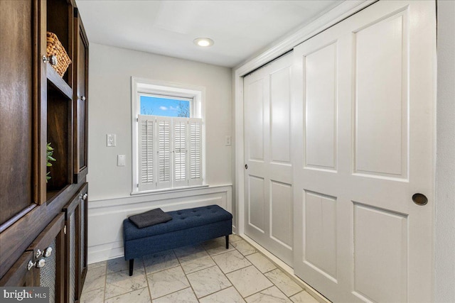 living area with a decorative wall, recessed lighting, a wainscoted wall, and marble finish floor