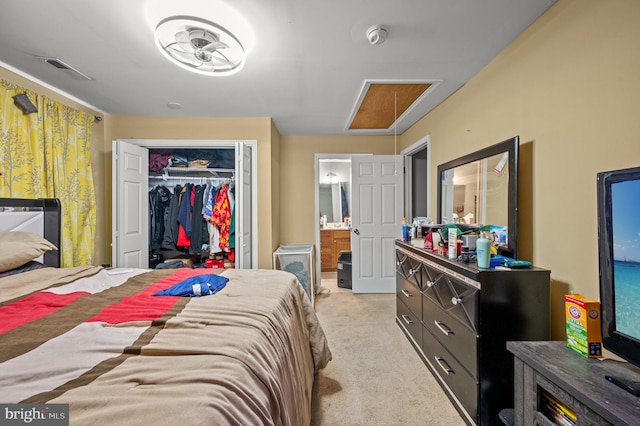 bedroom featuring a closet, visible vents, light colored carpet, and connected bathroom