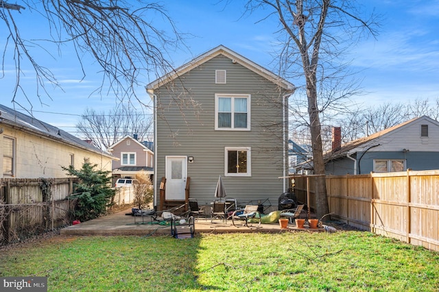 rear view of house with a fenced backyard, entry steps, a yard, and a patio