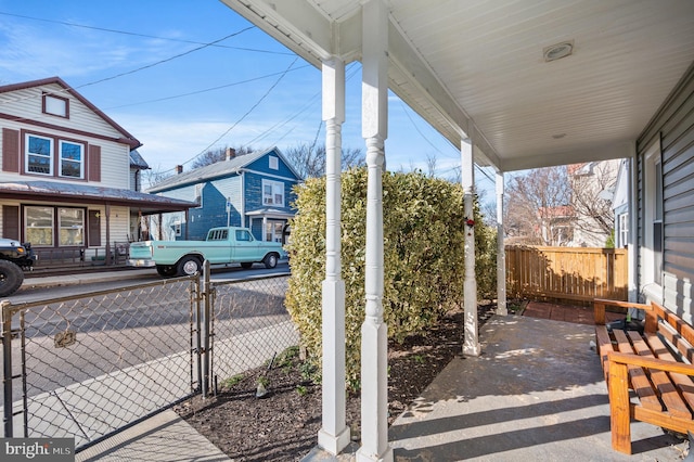 view of patio / terrace with a gate, covered porch, and fence