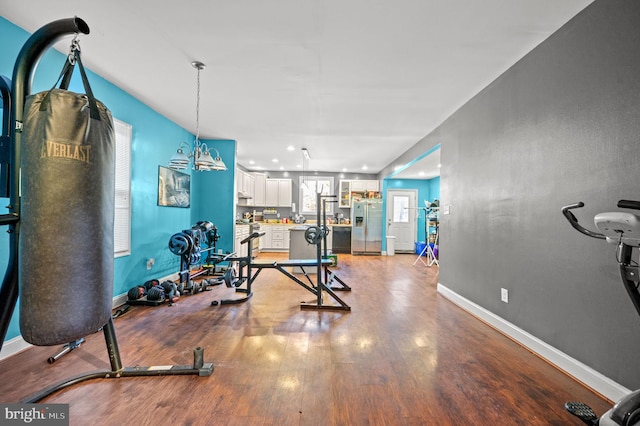 workout room with light wood finished floors and baseboards