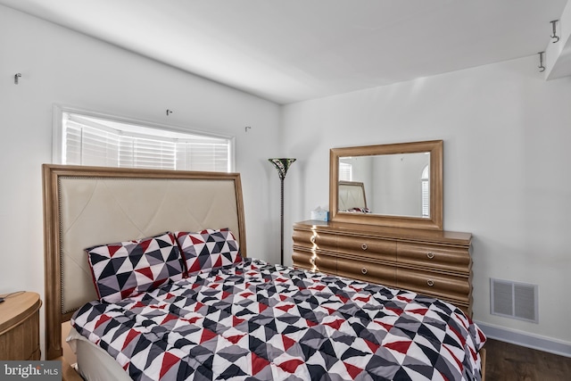 bedroom featuring visible vents and wood finished floors