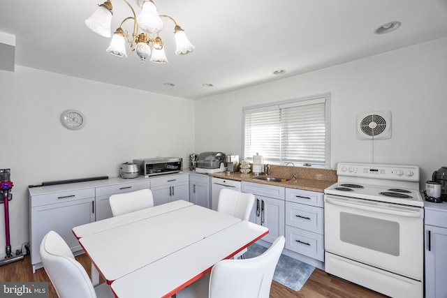 kitchen featuring visible vents, light countertops, a notable chandelier, white appliances, and a sink